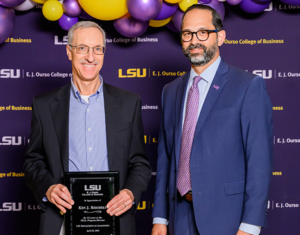 Kenneth Reichelt holds his award next to former LSU Ourso Dean Jared Llorens