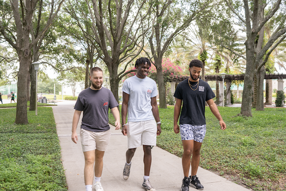 delta tau delta members walking on campus